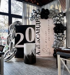 balloons are set up in front of a large sign and balloon arch for an anniversary celebration