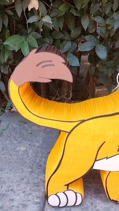 a large yellow banana sitting on top of a cement ground next to a planter