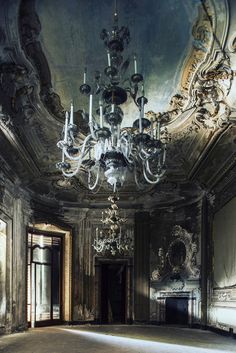 an empty room with chandeliers and paintings on the walls in black and white