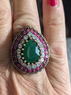 Luxurious Large and Heavy Turkish ring with translucent faceted Green Onyx center stone. Surrounded by vivid brilliant White Topaz and Raspberry Rubies. People stop me in my tracks when I wear this statement ring! I love wearing it but it's time to let someone else feel the fabulous feeling this ring possesses! 8.75 on a ring mandrel but fitting up to a 9.25 because of its hollow depth. Vintage Antique condition with nice patina, damage free.  All gemstones are firmly in place. Weight is 23 grams. Heavy Rings For Women, Teardrop Rings With Gemstone Accents As Gifts, Heavy Rings, Turkish Ring, Turkish Rings, Ring Mandrel, Emerald Band, Ladies Ring, Green Onyx