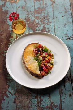 a white plate topped with a piece of food on top of a wooden table