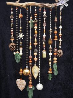 an assortment of beads and ornaments hanging from a tree branch with snowflakes on it