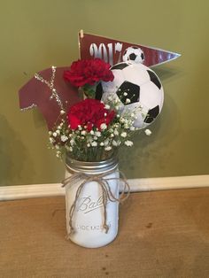 a mason jar filled with flowers and soccer balls