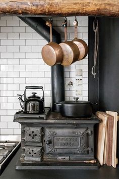 an old fashioned stove with pots and pans hanging from it