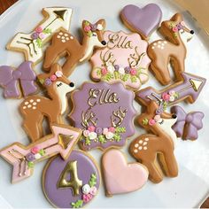 some decorated cookies are on a plate with pink and purple decorations, including deers