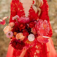 a woman in a red dress holding a bouquet of flowers