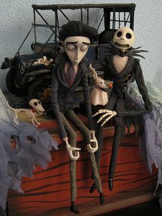 two skeletons sitting on top of a wooden box