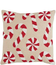 a red and white pillow with candy canes on it