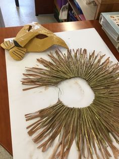 a wreath made out of sticks on a table next to a paper mache and scissors