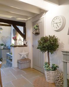 there is a clock on the wall and some plants in baskets next to the door