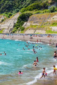 many people are playing in the water at the beach