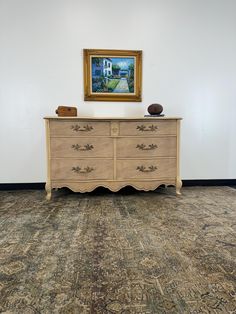 an old dresser is in the corner of a room with a painting on the wall