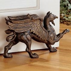 a statue of a horse with wings on it's back legs is standing in front of a door