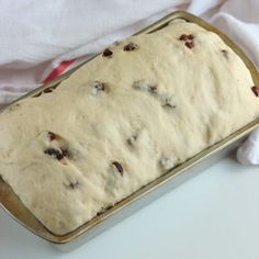 a loaf of bread sitting on top of a pan covered in icing and raisins