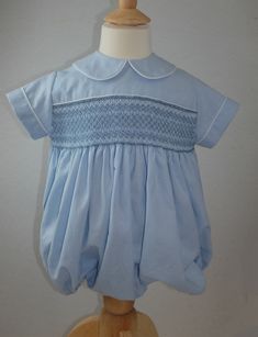 A beautiful hand smocked baby bubble romper in Japanese cotton, perfect for the little boy with a big occasion. Delicately hand smocked with a geometric design on the front, finished with crisp white piping and mother of pearl buttons in the back. Lined in 100% cotton. Each item is made to order so can be customised to your wishes, please leave a note at checkout or send me a message to discuss. Please allow up to two weeks for dispatch. Summer Cotton Smocked Bubble Romper, Summer Cotton Smock Bubble Romper, Summer Cotton Bubble Romper With Smocked Bodice, Spring Cotton Bubble Romper With Smocked Cuffs, White Smocked Cotton Bubble Romper, Cotton Fitted Bubble Romper With Smocked Back, White Cotton Smock Bubble Romper, Fitted Smock Bubble Romper For Summer, Cotton Smocked Dress For Baptism