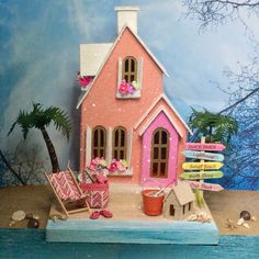 a pink doll house sitting on top of a wooden table next to a blue wall