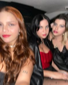 three beautiful women sitting next to each other in a car