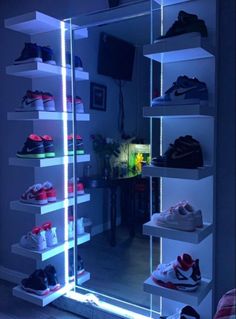 there are many shoes on the shelves in this room, all lit up with blue lights