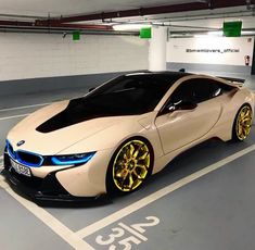 a white car with gold rims parked in a parking garage