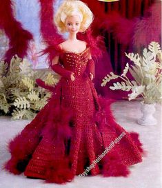 a barbie doll wearing a red dress with feathers