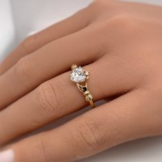 a woman's hand with a diamond ring on top of her finger and an engagement band