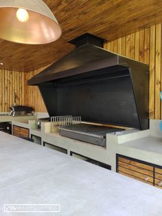 a kitchen with a large oven and counter tops in front of wood paneled walls