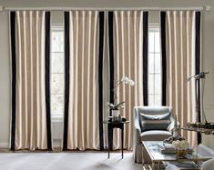 an elegant living room with black and white striped drapes on the windowsills