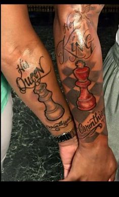 two people with tattoos on their arms holding hands and one has a chess piece in the other's hand