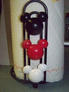 a mickey mouse toilet paper holder with two balls attached to it's sides and a red nose on top