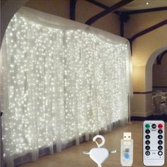 a room with white lights and remotes on the floor, along with a curtain