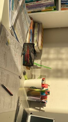 an open laptop computer sitting on top of a desk next to a pile of papers