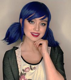 a woman with blue hair is posing for the camera