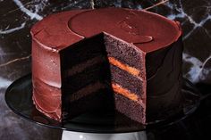 a chocolate cake on a plate with one slice cut out and ready to be eaten