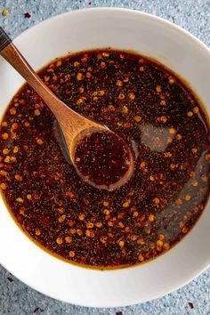 a white bowl filled with chili sauce and a wooden spoon