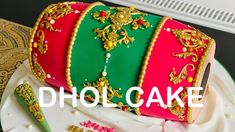 there is a cake that has been decorated with gold and green designs on it's side