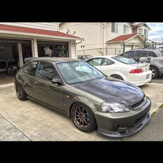 a grey car parked in front of a garage