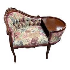 an old fashioned chair with floral fabric and wood trimmings on the arm rest