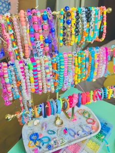 there are many bracelets hanging from the rack on the table and in front of them