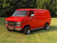 a red van is parked in the grass