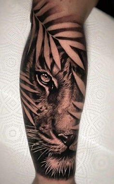 a black and white tiger with leaves on his head is shown in this tattoo design