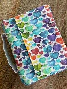 a pair of scissors sitting on top of a table next to a cloth covered with hearts