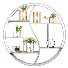 three shelves with plants, candles and clocks on them are arranged in the shape of a circle