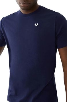 Tap into your style with this True Religion crewneck tee. Featuring just a small chest logo, it remains subtle while authentically branded. Soft 100% cotton fabric ensures comfort whether lounging or hitting the streets. At 29” in length it layers well yet won’t swallow your frame. Simple, solid and made to last—this top elevates any fit with understated West Coast vibes. Solid Crew Neck T-shirt With Logo Print, Solid Color Crew Neck T-shirt With Logo Print, Solid Crew Neck T-shirt With Logo, West Coast Vibes, Crew Neck Tshirt, Small Chest, Minimalist Logo, Jeans Brands, True Religion