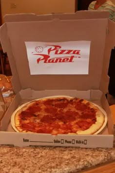 a pizza in a box sitting on top of a counter