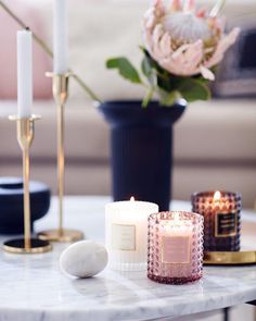 candles and flowers on a table in a living room