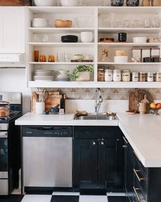 a kitchen with black and white checkered flooring, open shelving above the sink