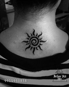 a black and white photo of a woman's neck with a sun tattoo on it