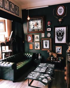 a living room filled with furniture and pictures on the wall next to a coffee table