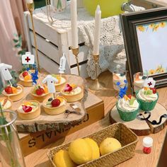 a table topped with lots of cupcakes and fruit