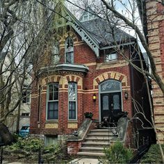 a red brick house with stairs leading up to the front door